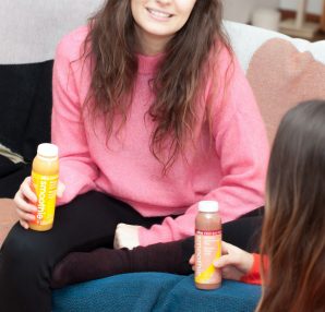 deux amies assises sur canapé avec smoothies