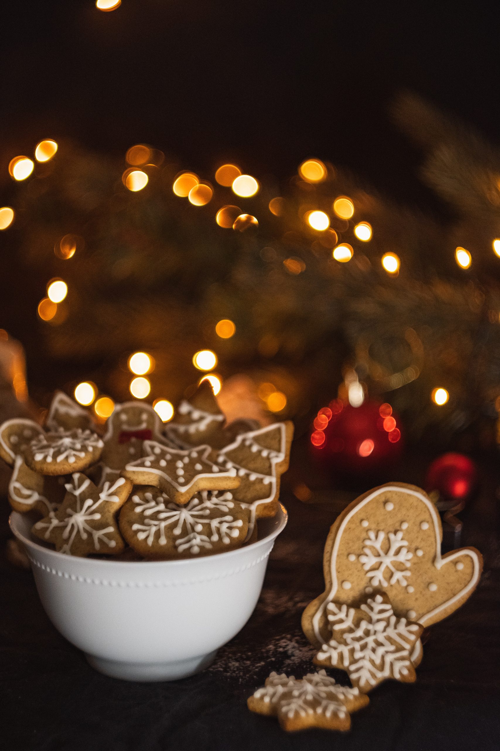 biscuits de noël dans un bol devant un sapin de noël éclairé