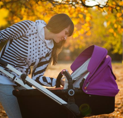 Jeune maman qui promène son bébé dans une poussette